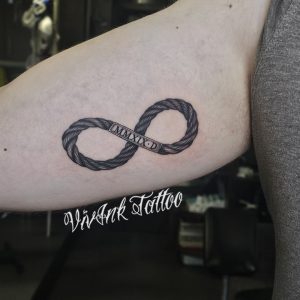 Végtelen acélsodrony tetoválás római számokkal bicepsz belsúő részén